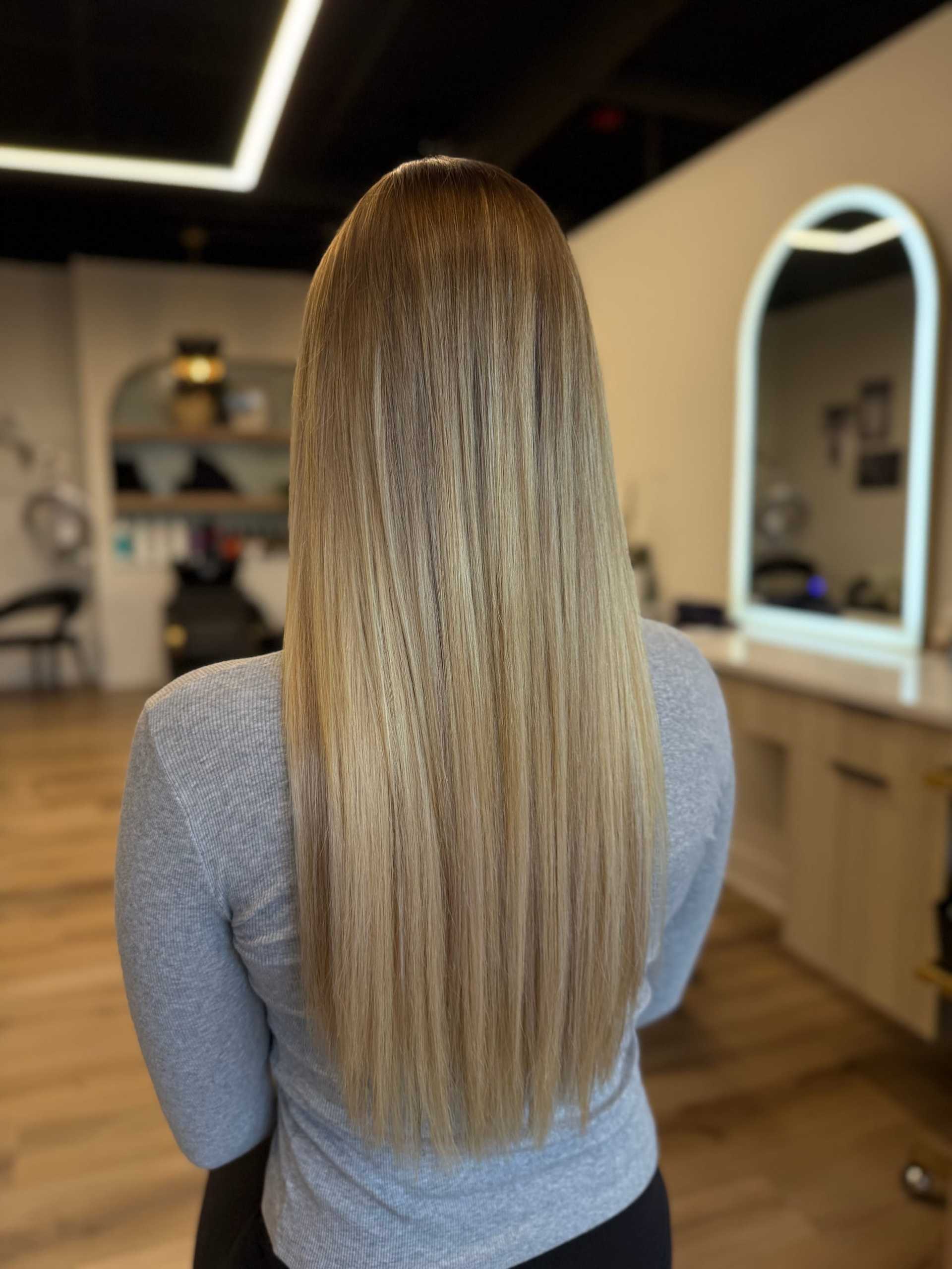 Woman with long, straight blonde hair in a salon setting.