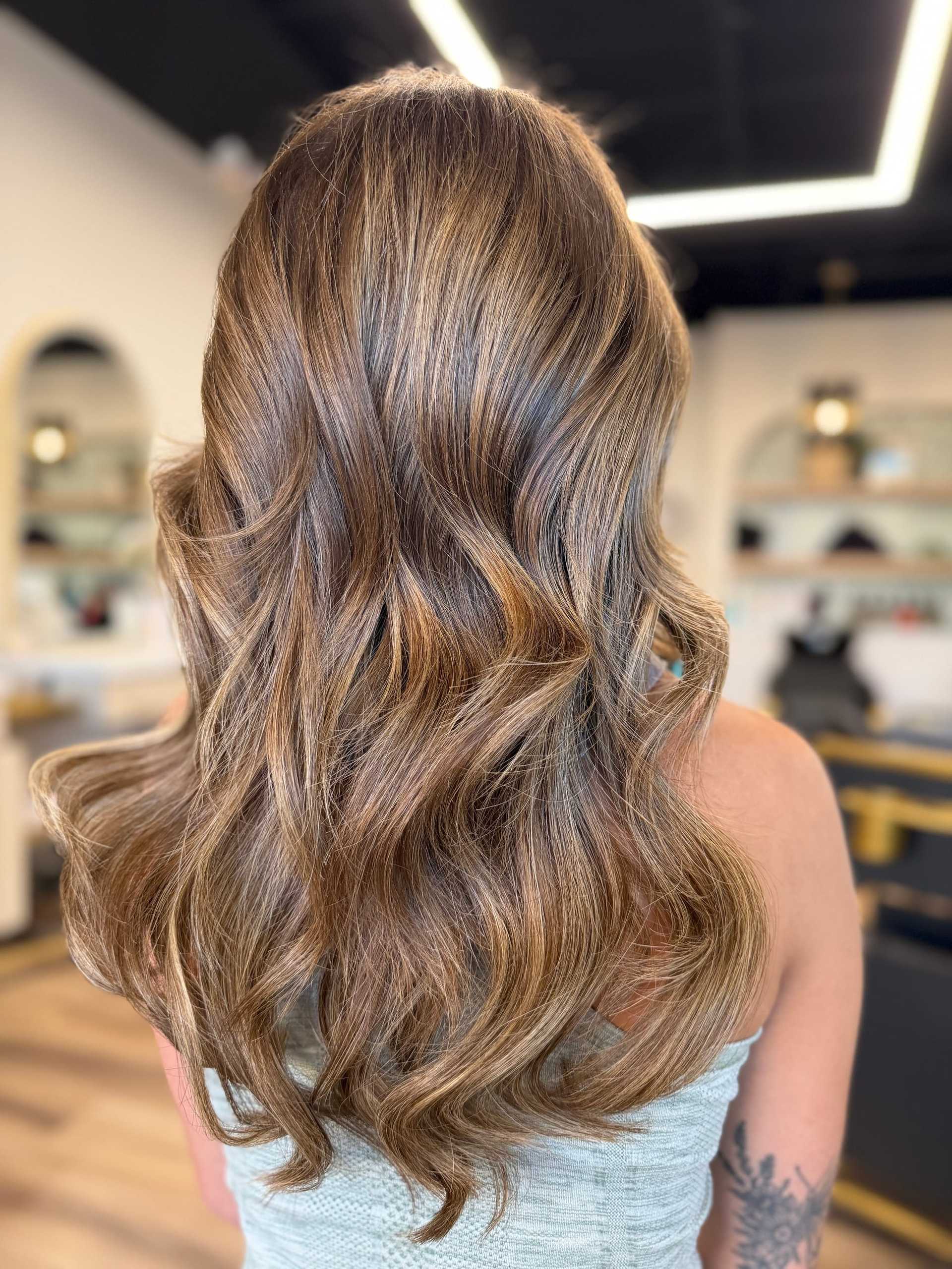 Wavy golden-brown hair styled elegantly in a salon setting.